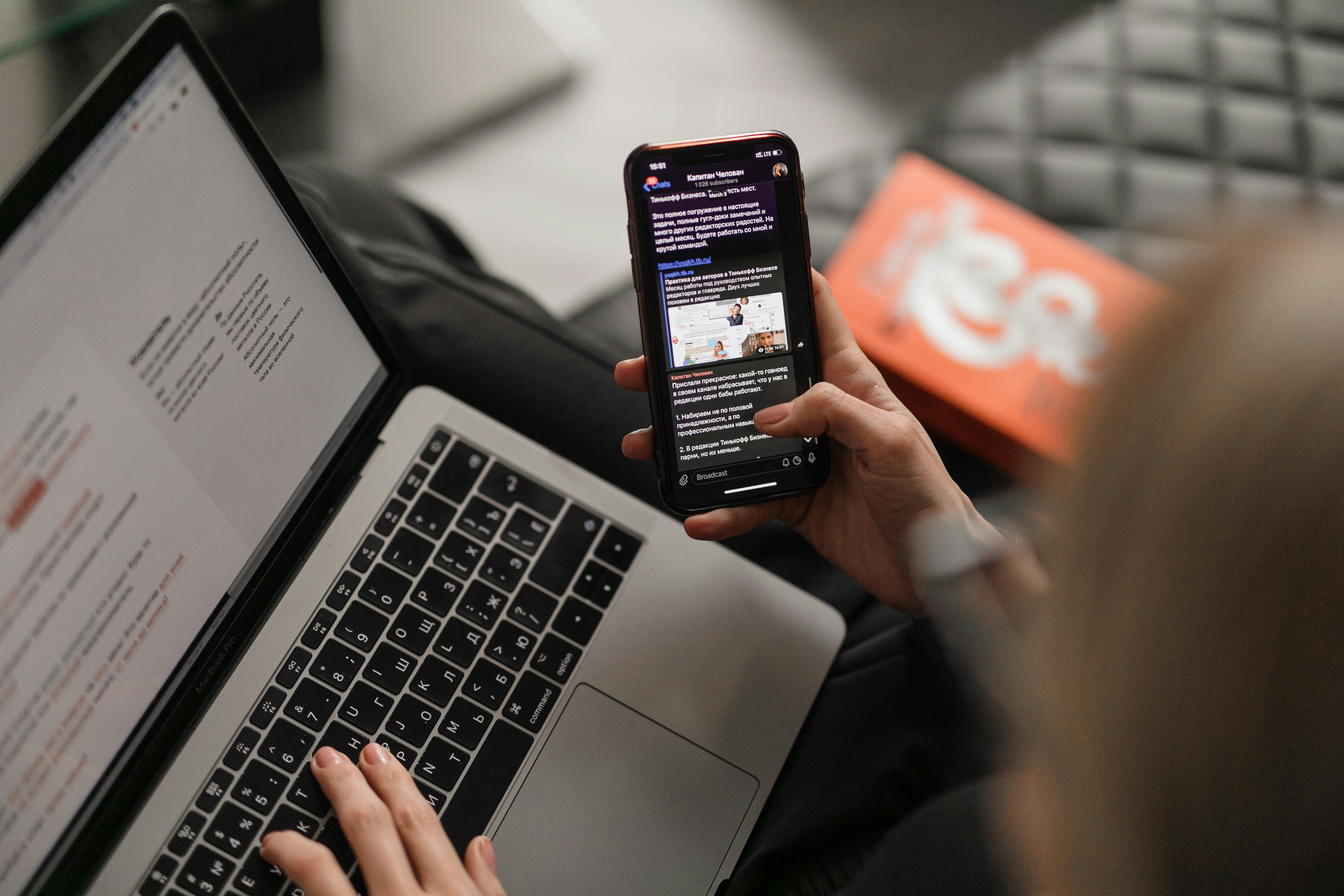 Young Kenyan entrepreneur managing multiple income streams on a phone and laptop